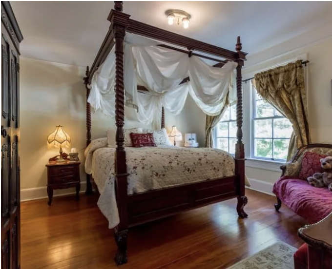 Victorian-inspired bedroom at Heceta Lighthouse Bed & Breakfast, with draped four-poster bed and vintage decor.